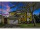 Two-story yellow home with a white garage door, arched entry, and solar panels at 8401 Secret Key Cv, Kissimmee, FL 34747