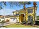 Yellow two-story home featuring a front-entry, white garage door, and well-manicured lawn at 8401 Secret Key Cv, Kissimmee, FL 34747