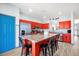 Modern kitchen featuring red cabinets, granite countertops, and a large center island with seating at 8401 Secret Key Cv, Kissimmee, FL 34747