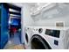 Convenient laundry room with modern washer and dryer units next to a doorway to an intergalactic themed room at 8401 Secret Key Cv, Kissimmee, FL 34747