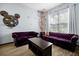 Living room with plush purple sofas, unique décor, and a coffee table presents a blend of style and relaxation at 8401 Secret Key Cv, Kissimmee, FL 34747