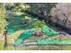 Community mini golf course with artificial turf, colorful obstacles, palm trees, and black metal fencing at 8401 Secret Key Cv, Kissimmee, FL 34747