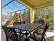 Screened patio featuring outdoor dining set and grill with views of the pool and yard at 8401 Secret Key Cv, Kissimmee, FL 34747