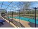 Screened-in pool with protective fence, seamlessly blending indoor/outdoor living with mature tree views at 8401 Secret Key Cv, Kissimmee, FL 34747