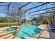 Screened-in pool area with hot tub, waterslide, and a view of the water at 8401 Secret Key Cv, Kissimmee, FL 34747
