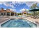 Community pool area with jacuzzi, lounge chairs, and palm trees under a partly cloudy sky at 8401 Secret Key Cv, Kissimmee, FL 34747