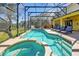 Large screened-in pool featuring sun loungers, slide, and an attached jacuzzi at 8401 Secret Key Cv, Kissimmee, FL 34747