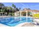 Resort-style pool surrounded by lounge chairs and lush landscaping with palms at 8401 Secret Key Cv, Kissimmee, FL 34747