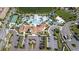 Aerial view of the community pool with lazy river, tennis court, clubhouse, parking, and beautiful landscaping at 8936 Sydney Ave, Kissimmee, FL 34747