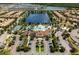 Aerial view showcasing the community pool, clubhouse, and surrounding homes nestled around a tranquil lake at 8936 Sydney Ave, Kissimmee, FL 34747
