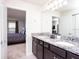 Bathroom vanity with double sinks, granite countertop, and doorway to bedroom at 8936 Sydney Ave, Kissimmee, FL 34747