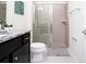 Tiled walk-in shower stall and dark cabinets with granite countertops in bathroom at 8936 Sydney Ave, Kissimmee, FL 34747