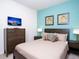 Comfortable bedroom features a dresser with TV, stylish decor, and a wood-framed bed at 8936 Sydney Ave, Kissimmee, FL 34747