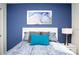 Stylish bedroom boasts a plush bed with colorful pillows against a deep blue accent wall at 8936 Sydney Ave, Kissimmee, FL 34747