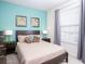 Comfortable bedroom features stylish decor, including a wood-framed bed, plush bedding, and tasteful wall art at 8936 Sydney Ave, Kissimmee, FL 34747