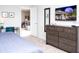 Comfortable bedroom with a dresser, modern decor, and doorway to the living area beyond at 8936 Sydney Ave, Kissimmee, FL 34747