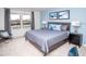 Calm bedroom featuring a cozy bed, stylish furnishings, and natural light from the window at 8936 Sydney Ave, Kissimmee, FL 34747