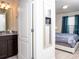 View of bedroom with stylish decor and comfortable bed from bathroom at 8936 Sydney Ave, Kissimmee, FL 34747