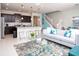 Open-concept living room with a modern kitchen, seating area, and view of the staircase to the upper level at 8936 Sydney Ave, Kissimmee, FL 34747