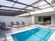 Private pool featuring lounge chairs and a covered area with an outdoor dining set for luxury enjoyment at 8936 Sydney Ave, Kissimmee, FL 34747