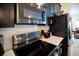 Close-up of kitchen range and microwave with dark cabinets and stainless steel appliances at 978 Splash Shot Pl, Davenport, FL 33896