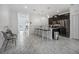 Bright kitchen with white island, marble floors, stainless appliances, and dark cabinets at 978 Splash Shot Pl, Davenport, FL 33896