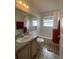 Bathroom with a tiled shower-tub combo, single sink vanity, and patterned flooring at 1010 Prey Ct, Kissimmee, FL 34746