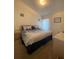Comfortable bedroom with a large bed, neutral carpet, and a view of the outdoors at 1010 Prey Ct, Kissimmee, FL 34746