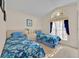 Bright bedroom featuring two twin beds, an arched window, and a neutral color scheme at 1010 Prey Ct, Kissimmee, FL 34746