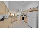 Bright kitchen featuring white appliances, tan cabinetry, and tile flooring at 1010 Prey Ct, Kissimmee, FL 34746