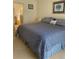 Spacious main bedroom featuring a large bed, neutral carpet, and ensuite bathroom at 1010 Prey Ct, Kissimmee, FL 34746