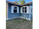 Corner exterior view of a blue house featuring white trim and open crawl space at 1011 26Th Street, Orlando, FL 32805