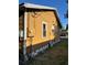 Exterior shot of home showing yellow siding, utility lines and meters at 1011 26Th Street, Orlando, FL 32805