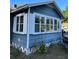 Exterior corner of blue home with large windows, white trim and concrete block foundation at 1011 26Th Street, Orlando, FL 32805