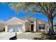 Charming home featuring a well-manicured lawn, mature tree, and attached two-car garage in a quiet neighborhood at 1017 Winding Water Way, Clermont, FL 34714