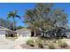 Inviting single-Gathering home boasts mature landscaping, including a palm tree, and an attached two-car garage at 1017 Winding Water Way, Clermont, FL 34714