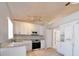 Bright kitchen with white cabinets, stainless appliances, granite countertops and tile floors at 1017 Winding Water Way, Clermont, FL 34714