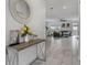 Hallway view leads to living area, featuring white marble tile, console table, and glimpse of the open floor plan at 1034 Splash Shot Pl, Davenport, FL 33896