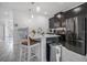 Modern kitchen boasts a center island with seating, sleek black cabinetry, and stainless steel appliances at 1034 Splash Shot Pl, Davenport, FL 33896