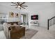 Cozy living room with neutral tones, a flat screen tv and staircase at 1034 Splash Shot Pl, Davenport, FL 33896