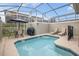 Screened-in pool area with lounge chairs, table and chairs, and grill, perfect for relaxation and entertaining at 1034 Splash Shot Pl, Davenport, FL 33896