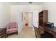 Bright office space with a comfortable chair and a view into a colorful living area at 1335 Palmetto Dunes St, Davenport, FL 33836