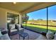 Inviting screened patio with wicker furniture and picturesque golf course views at 1335 Palmetto Dunes St, Davenport, FL 33836