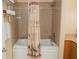 Well-lit bathroom featuring a tiled shower-tub combination with palm tree patterned shower curtain at 13427 Blue Heron Beach Dr # 1607, Orlando, FL 32821