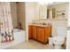 Bright bathroom featuring a shower-tub combination, wooden cabinetry, and neutral tile flooring at 13427 Blue Heron Beach Dr # 1607, Orlando, FL 32821