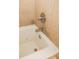 Close-up of a soaking tub with chrome faucet and spray attachment, surrounded by beige tiling at 13427 Blue Heron Beach Dr # 1607, Orlando, FL 32821