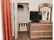 Bedroom featuring a dresser with a television and an open closet for storage at 13427 Blue Heron Beach Dr # 1607, Orlando, FL 32821