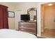 Comfortable bedroom featuring a dresser with a mounted television and decorative mirror at 13427 Blue Heron Beach Dr # 1607, Orlando, FL 32821