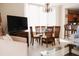 Well-lit dining area with a glass-top table, wood chairs, and views to the kitchen and living room at 13427 Blue Heron Beach Dr # 1607, Orlando, FL 32821