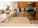 The kitchen features a stainless steel sink, granite countertops, wood cabinets and updated appliances at 13427 Blue Heron Beach Dr # 1607, Orlando, FL 32821